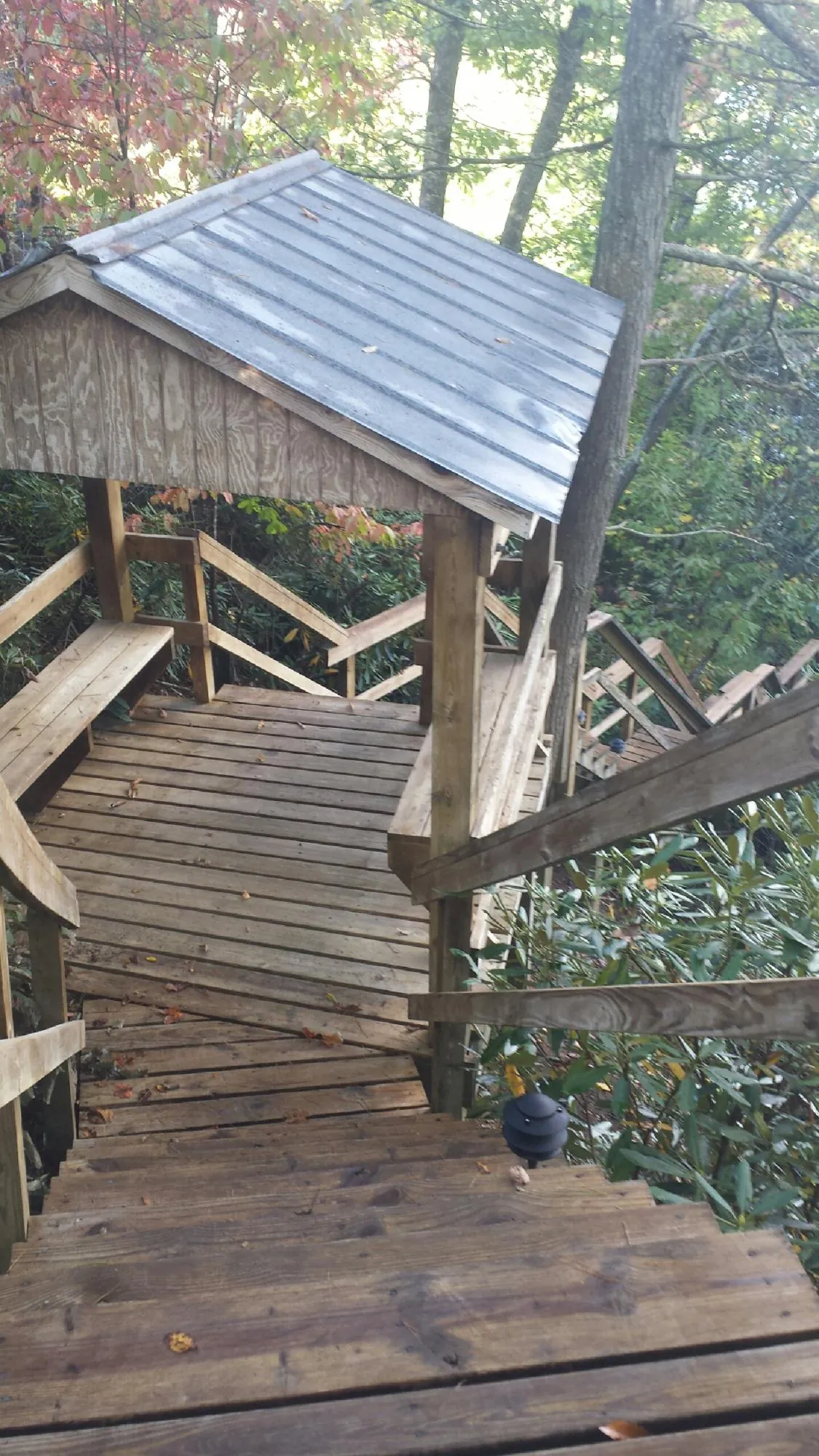 Metal roofed shelter over wooden steps on a wooded walkway — Skylight Repair & Installation work by our crew in Gray
